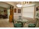 Charming dining area featuring a glass table and teal chairs, view to living room at 3721 Monday Ter, North Port, FL 34286