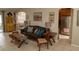 Living room with brown leather couch and view into the kitchen at 3721 Monday Ter, North Port, FL 34286