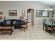 Open living and dining room with tile floors and a brown couch at 3721 Monday Ter, North Port, FL 34286