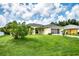One-story house with a grassy yard, featuring a screened-in porch and palm trees at 3721 Monday Ter, North Port, FL 34286