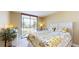 Bedroom with a floral comforter and access to balcony at 25188 Marion Ave # D101, Punta Gorda, FL 33950
