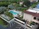 Aerial view of community pool, spa, tennis courts, and lush landscaping at 25188 Marion Ave # D101, Punta Gorda, FL 33950