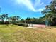 Tennis court surrounded by lush greenery at 1185 Bayshore Dr, Englewood, FL 34223