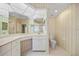 Bright bathroom featuring tiled floor, wallpaper, toilet, and vanity with large mirror at 3800 Bal Harbor Blvd # 212, Punta Gorda, FL 33950