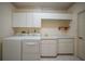 Functional laundry room with sink, countertop, storage cabinets, and modern washer and dryer at 3800 Bal Harbor Blvd # 212, Punta Gorda, FL 33950