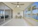 Bright sunroom boasting waterfront views through expansive windows, tiled floors, and a ceiling fan at 3800 Bal Harbor Blvd # 212, Punta Gorda, FL 33950