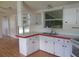 Kitchen with white cabinets, double sink, and wood-look flooring at 5787 Holiday Park Blvd, North Port, FL 34287