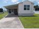 Single-wide manufactured home with carport and landscaped yard at 5787 Holiday Park Blvd, North Port, FL 34287