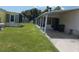 View of the home's exterior, showing a carport and lawn at 5787 Holiday Park Blvd, North Port, FL 34287