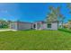 Newly built home with gray siding, landscaping, and a gray garage door at 4582 Enid Ln, North Port, FL 34288