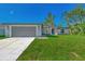 Newly built home with a gray garage door and a well-manicured lawn at 4582 Enid Ln, North Port, FL 34288