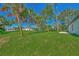 Backyard of home with grassy area and palm trees at 4582 Enid Ln, North Port, FL 34288