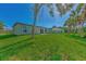 House with backyard, lush grass and palm trees at 4582 Enid Ln, North Port, FL 34288