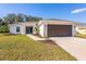 Newly constructed home with a modern exterior, two-car garage, and landscaped front yard at 1019 Cazenovia St, Port Charlotte, FL 33952