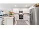 A modern kitchen featuring white cabinetry, stainless steel appliances, a peninsula with seating, and an open layout at 16429 Bridle Ridge St, Port Charlotte, FL 33953