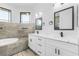 Luxurious bathroom featuring double sinks, a modern bathtub, and elegant tile work at 24051 Pyramid Way, Punta Gorda, FL 33955