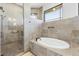 Luxurious bathroom featuring a walk-in shower and modern bathtub at 24051 Pyramid Way, Punta Gorda, FL 33955
