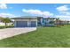 Stunning home with a lush lawn and a brick driveway leading to a two-car garage at 24051 Pyramid Way, Punta Gorda, FL 33955
