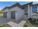 Contemporary home with a two-car garage and a well-maintained stone walkway at 24051 Pyramid Way, Punta Gorda, FL 33955