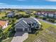 Stunning waterfront home featuring a metal roof, paver driveway, lush landscaping, and a two-car garage at 24051 Pyramid Way, Punta Gorda, FL 33955