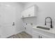 Laundry room with cabinets, sink, modern fixtures and luxury vinyl plank flooring at 24051 Pyramid Way, Punta Gorda, FL 33955