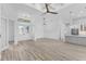 Open-concept living space with light wood floors seamlessly connects the living room and kitchen at 24051 Pyramid Way, Punta Gorda, FL 33955
