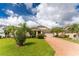 Tan two-story house with brick paver driveway and landscaping at 28178 Arrowhead Cir, Punta Gorda, FL 33982