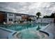 Community pool with patio furniture, and building view at 4158 Tamiami Trl # U6, Port Charlotte, FL 33952