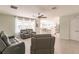 Open living room and kitchen with gray reclining sofas and tile flooring at 27261 Guapore Dr, Punta Gorda, FL 33983