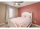 Bedroom with a white bed frame, pink wall, and window at 27261 Guapore Dr, Punta Gorda, FL 33983