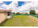 Backyard view of a single-story house with a screened porch and large yard at 600 Beeche Nw Ter, Port Charlotte, FL 33948