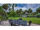 Backyard featuring a patio table and chairs, green lawn, and access to canal and boat dock at 2256 Auburn Blvd, Port Charlotte, FL 33948