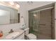 Well-lit bathroom with a modern sink, granite countertop, toilet, and a tiled shower with a glass door at 2256 Auburn Blvd, Port Charlotte, FL 33948