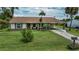 Charming single-story home featuring a brick-accented facade, manicured lawn, and a covered carport at 2256 Auburn Blvd, Port Charlotte, FL 33948