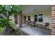 Inviting front porch with seating, brick accents, and views of the landscaped yard at 2256 Auburn Blvd, Port Charlotte, FL 33948