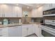 Well-lit kitchen boasts white cabinetry, granite countertops, and modern appliances at 2256 Auburn Blvd, Port Charlotte, FL 33948
