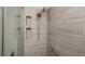 Up close view of modern tile shower with built-in shower niches, rain-style head, and grab bar at 2256 Auburn Blvd, Port Charlotte, FL 33948