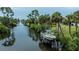Scenic waterfront view featuring a private boat dock, lush tropical landscaping, and serene canal access at 2256 Auburn Blvd, Port Charlotte, FL 33948
