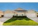 Front view of a charming tan house with two garages at 7457 W Lenox Cir, Punta Gorda, FL 33950
