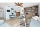 Living room with light teal walls, wood floors, and built-in shelving at 6420 Drucker Cir, Port Charlotte, FL 33981