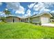 Tan house with a large grassy yard, palm trees, and a two-car garage at 20222 Banner Ave, Port Charlotte, FL 33952