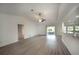 Spacious living room with vaulted ceiling, vinyl plank flooring, and sliding glass doors at 20222 Banner Ave, Port Charlotte, FL 33952