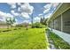 Backyard view showing grassy area and screened patio at 20222 Banner Ave, Port Charlotte, FL 33952