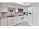 Bright kitchen featuring white cabinets, granite countertops, and modern appliances at 108 Boundary Blvd # A&B, Rotonda West, FL 33947