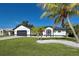 House exterior featuring a landscaped yard and palm trees at 9310 Rosebud Cir, Port Charlotte, FL 33981