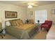 Bedroom with ceiling fan, large bed and sitting area at 3719 Albatros Ln, North Port, FL 34288