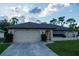 Single-story home with a two-car garage and a well-maintained lawn at 1565 Dorchester St, Port Charlotte, FL 33952