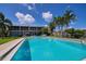 Community pool with surrounding patio furniture and lush landscaping at 3251 White Ibis Ct # C4, Punta Gorda, FL 33950