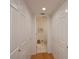 A long hallway with white closets and wood floors leading to a small bathroom at 3251 White Ibis Ct # C4, Punta Gorda, FL 33950