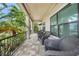 Spacious covered porch with wicker furniture and a view of tropical landscaping at 28 Colony Point Dr, Punta Gorda, FL 33950